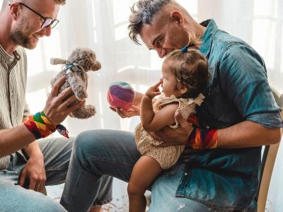 Male couple playing with toddler